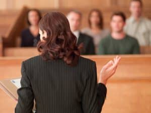 Lawyer holding document and speaking to jury in courtroom