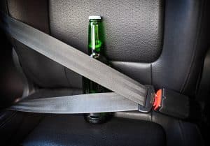 Bottle of alcohol fastened with seat belts. Drink and drive. Bottle of beer inside the car. Don't Drink for Drive.